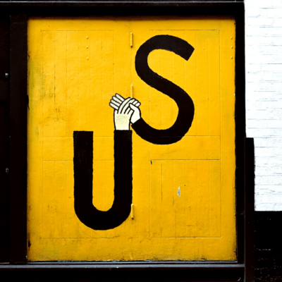 Graffiti représentant deux mains qui se rejoignent et forme un "US", nous en anglais.