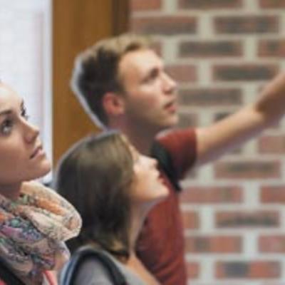 trois étudiants d'ostéopathie regardant un tableau d'informations