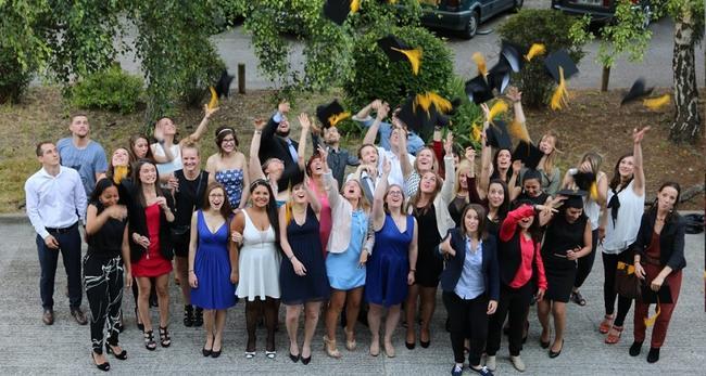 Groupe d'étudiant en fin d'études jetant leur diplôme dans les airs de l'école d'ostéopathie Ostéobio Paris